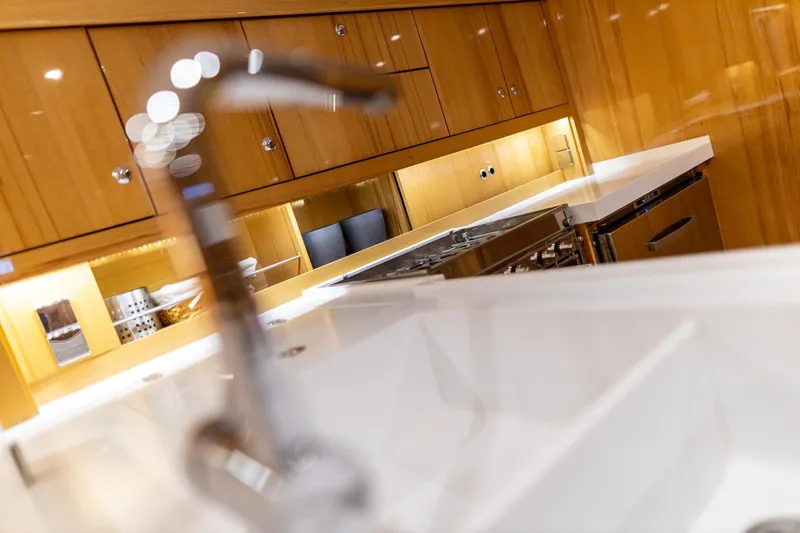  Yacht Photos Pics Luxurious kitchen interior of 2013 Hanse 630e yacht with modern fixtures and wooden cabinetry.