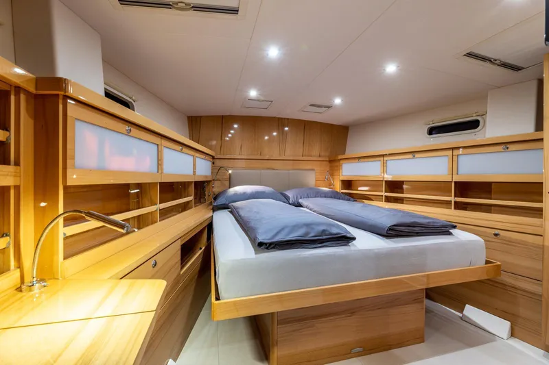  Yacht Photos Pics Luxurious cabin interior of 2013 Hanse 630e yacht with wooden furnishings and cozy bedding.