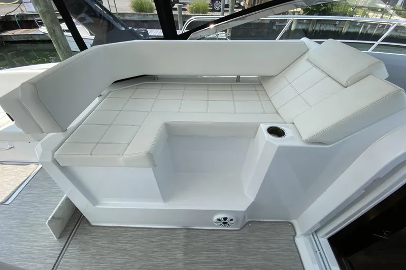  Yacht Photos Pics 2021 Cruisers Yachts 390 Express Coupe interior seating with white upholstery and cup holder.