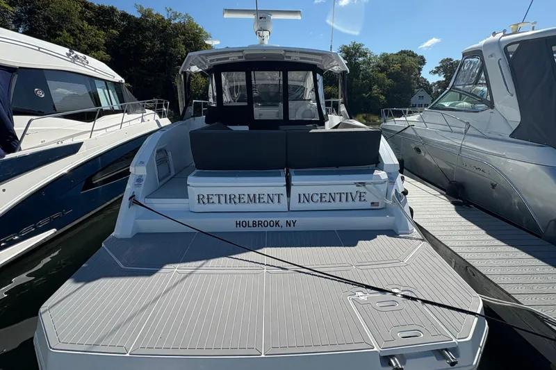  Yacht Photos Pics 2021 Cruisers Yachts 390 Express Coupe docked, rear view, "Retirement Incentive" name visible.