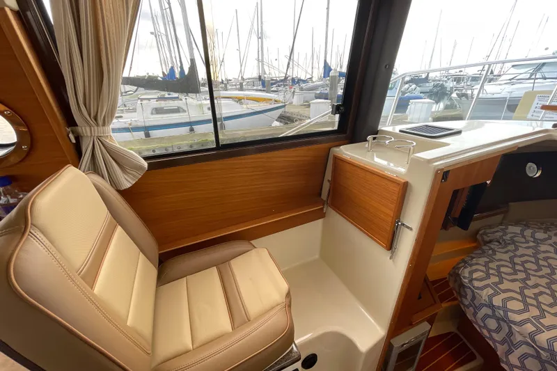 Poseidon&rsquo;s Lanai Yacht Photos Pics Interior of 2021 Ranger Tugs R-29 CB with seating and marina view.