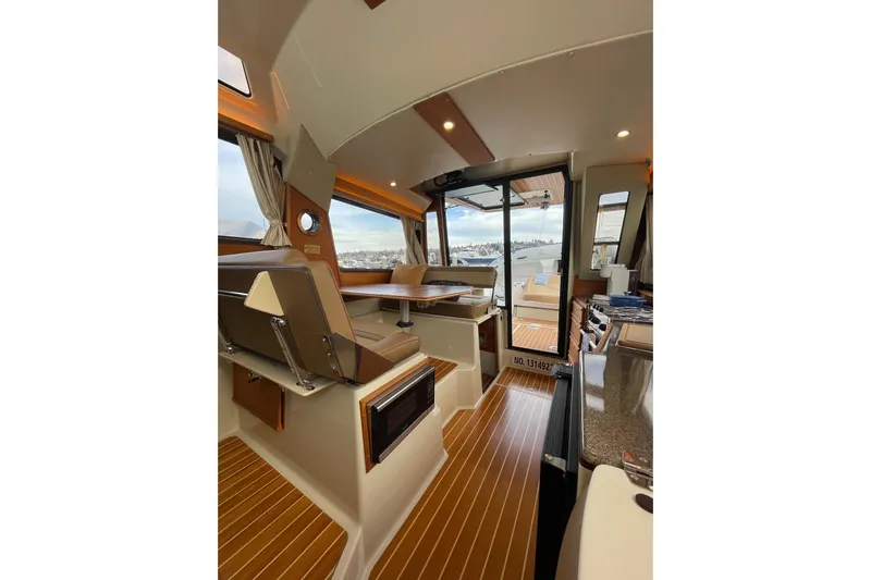 Poseidon&rsquo;s Lanai Yacht Photos Pics Interior of 2021 Ranger Tugs R-29 CB boat with modern seating and wood flooring.