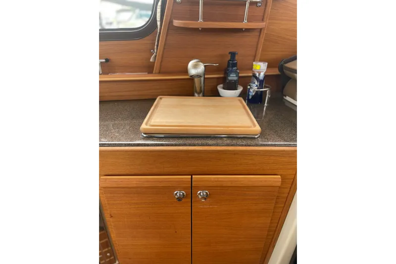 Poseidon&rsquo;s Lanai Yacht Photos Pics 2021 Ranger Tugs R-29 CB galley with wooden cabinetry and countertop accessories.