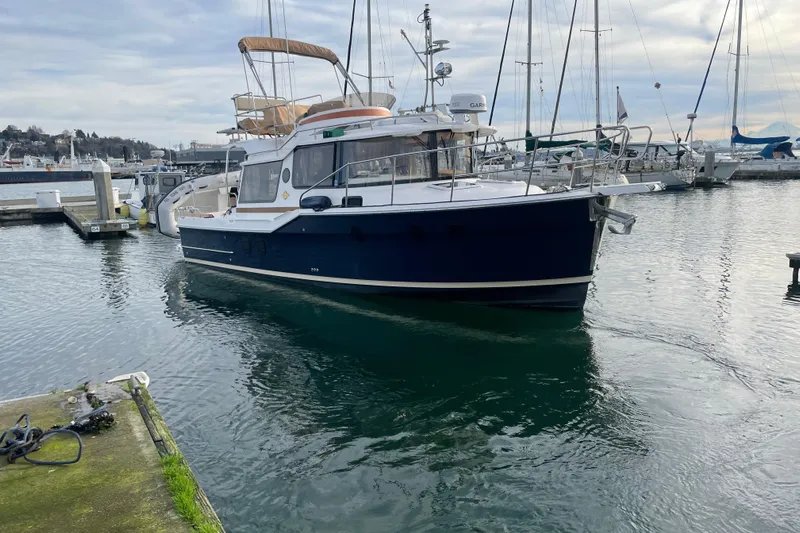 Poseidon&rsquo;s Lanai Yacht Photos Pics 2021 Ranger Tugs R-29 CB boat docked in a marina, calm water, overcast sky.