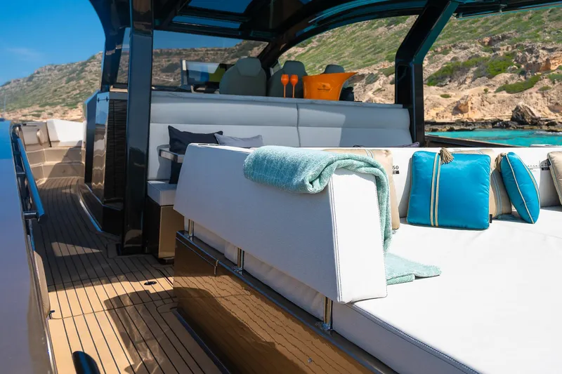  Yacht Photos Pics Luxurious Tesoro GOLDFINGER T50 yacht interior with elegant seating and scenic coastal view.