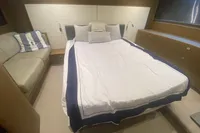Luxurious bedroom interior of 2016 Princess V48 Open yacht with elegant bedding and seating.