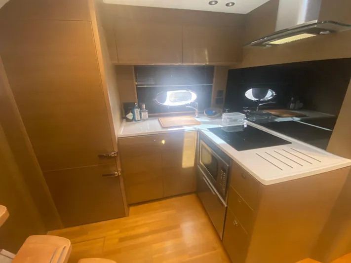  Yacht Photos Pics Modern kitchen interior of 2016 Princess V48 Open yacht, featuring sleek cabinetry and appliances.