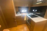 Modern kitchen interior of 2016 Princess V48 Open yacht, featuring sleek cabinetry and appliances.