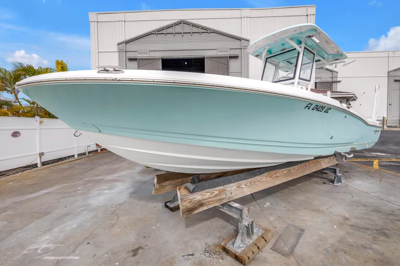  Yacht Photos Pics 2025 Caymas 28 HB boat in light blue, displayed on a stand outside a warehouse.