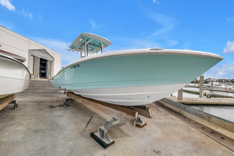  Yacht Photos Pics 2025 Caymas 28 HB boat on dock, light blue hull, marina background.