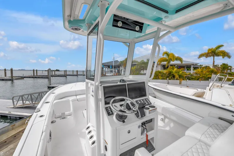  Yacht Photos Pics 2025 Caymas 28 HB boat cockpit with modern controls, docked by a scenic waterfront.