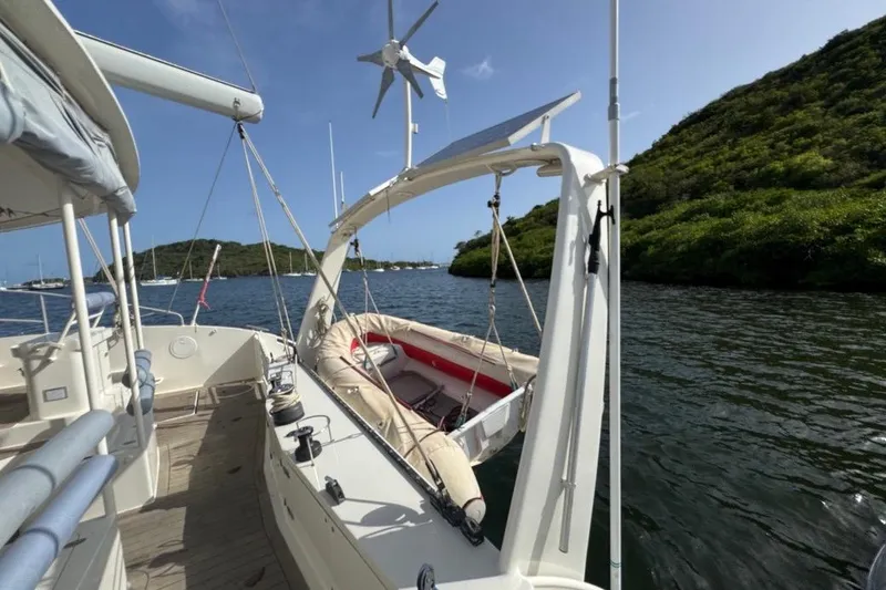 Alita Too Yacht Photos Pics Custom COAST 50 sailboat with dinghy, solar panels, and wind turbine on a sunny day.