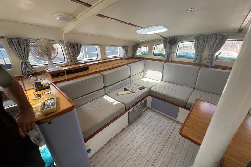 Alita Too Yacht Photos Pics Cozy interior of 2018 Custom COAST 50 boat with cushioned seating and wooden accents.