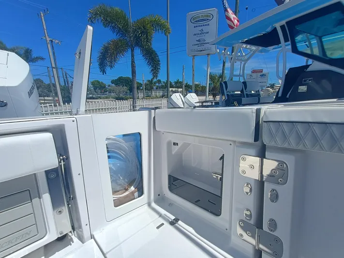 302-126 Yacht Photos Pics 2025 Blackfin 302 DC boat interior with storage compartments and seating, under a clear blue sky.