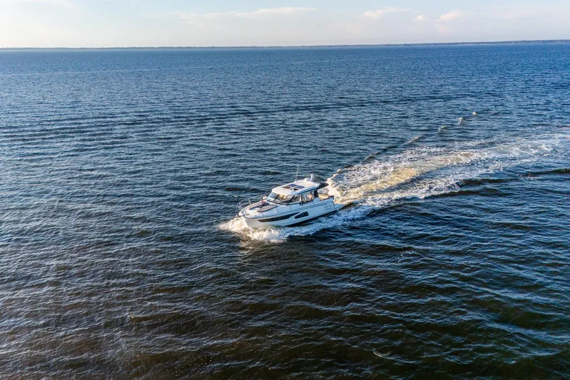Bella Thalassa Yacht Photos Pics 2021 Jeanneau NC 1095 cruising on open water under a clear sky.