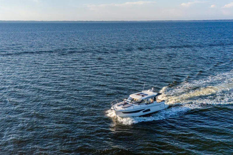 Bella Thalassa Yacht Photos Pics 2021 Jeanneau NC 1095 cruising on open water under a clear sky.