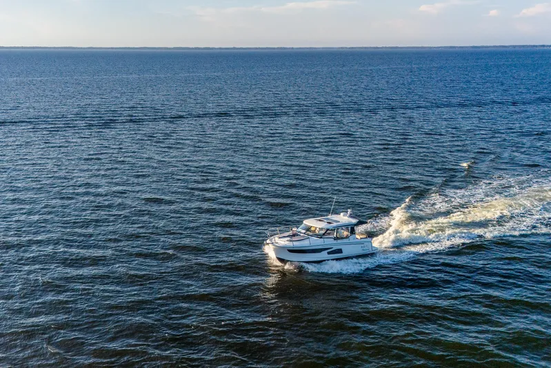 Bella Thalassa Yacht Photos Pics 2021 Jeanneau NC 1095 cruising on open water under clear skies.