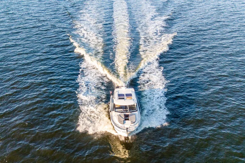 Bella Thalassa Yacht Photos Pics Aerial view of 2021 Jeanneau NC 1095 motorboat cruising on open water.