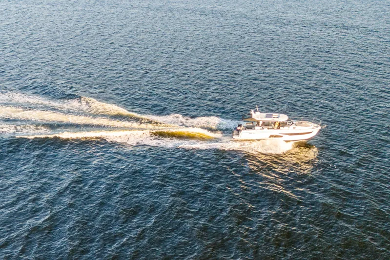 Bella Thalassa Yacht Photos Pics Aerial view of 2021 Jeanneau NC 1095 cruising on open water.