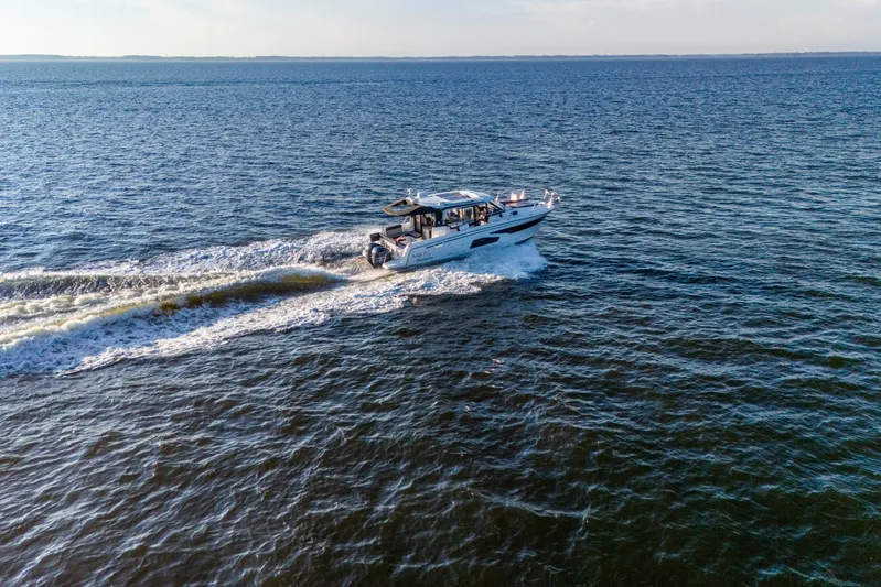 Bella Thalassa Yacht Photos Pics 2021 Jeanneau NC 1095 cruising on open water, creating a wake behind.