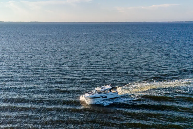 Bella Thalassa Yacht Photos Pics 2021 Jeanneau NC 1095 cruising on open water under a clear sky.