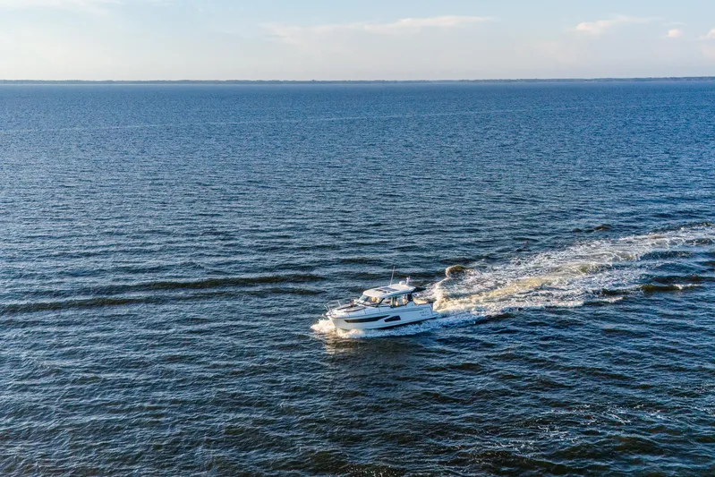 Bella Thalassa Yacht Photos Pics 2021 Jeanneau NC 1095 cruising on open water under a clear sky.
