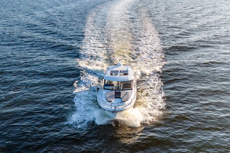 Bella Thalassa Yacht Photos Pics 2021 Jeanneau NC 1095 motorboat cruising on open water, aerial view.