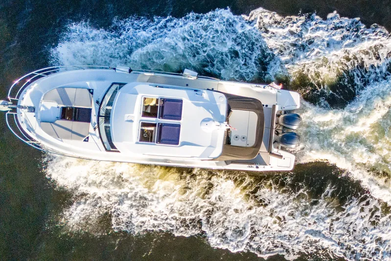 Bella Thalassa Yacht Photos Pics Aerial view of 2021 Jeanneau NC 1095 motorboat cruising on water.