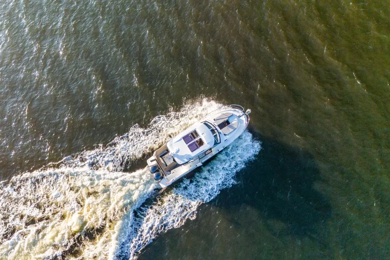 Bella Thalassa Yacht Photos Pics Aerial view of 2021 Jeanneau NC 1095 motorboat cruising on open water.