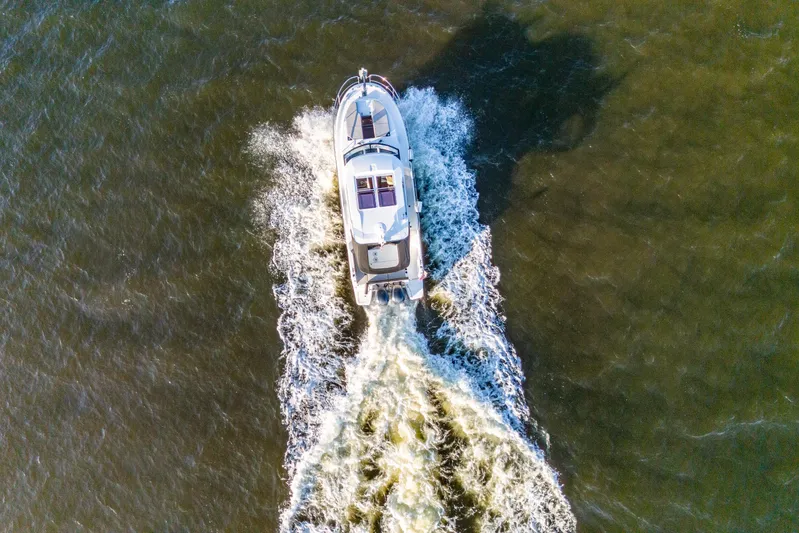 Bella Thalassa Yacht Photos Pics Aerial view of 2021 Jeanneau NC 1095 motorboat cruising on open water.