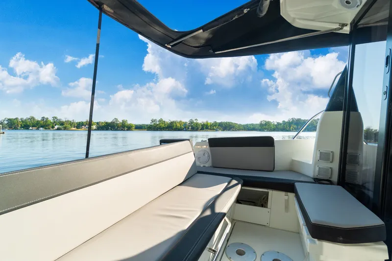Bella Thalassa Yacht Photos Pics 2021 Jeanneau NC 1095 boat interior with seating, overlooking serene lake and blue sky.