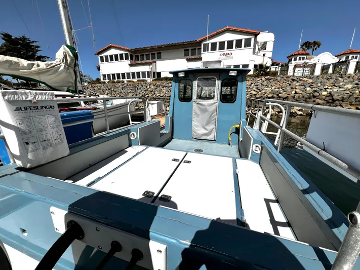 Acb Yacht Photos Pics Small blue boat docked near a building, featuring a Lifesling2 safety device.