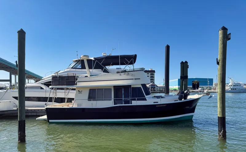#r Dream Yacht Photos Pics 2005 Mainship 400 Trawler docked in harbor under clear sky.