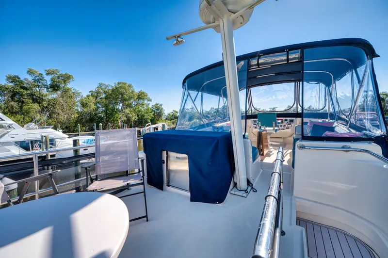 #r Dream Yacht Photos Pics 2005 Mainship 400 Trawler with blue canopy and outdoor seating area.