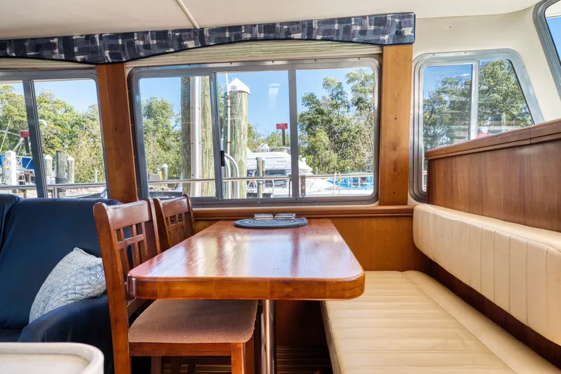 #r Dream Yacht Photos Pics Interior of a 2005 Mainship 400 Trawler with wooden table and seating.