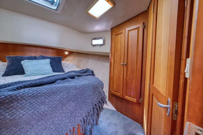 #r Dream Yacht Photos Pics Interior of 2005 Mainship 400 Trawler with cozy bed and wooden cabinets.