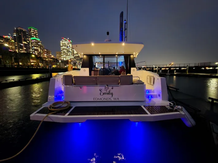 Emily Yacht Photos Pics 2022 Fountaine Pajot MY4.S yacht docked at night, city skyline in background.