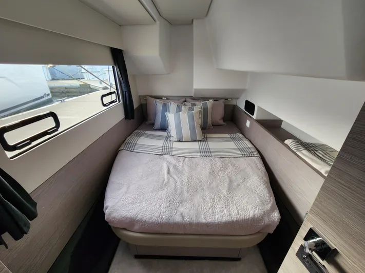 Emily Yacht Photos Pics Cozy cabin interior of 2022 Fountaine Pajot MY4.S with bed and striped pillows.