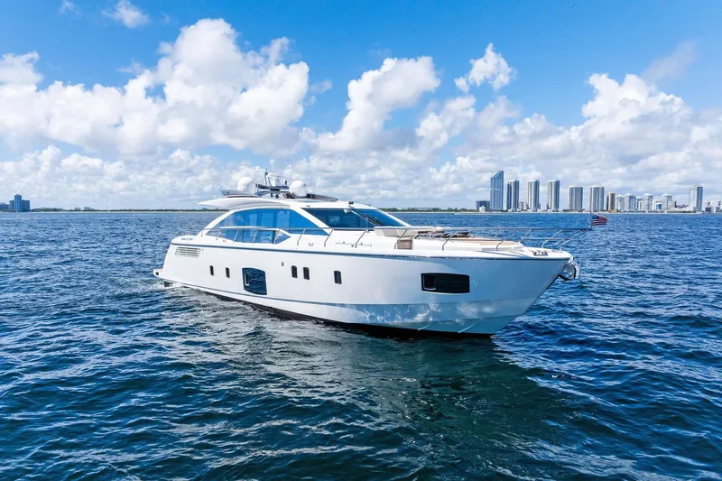 Blue Daksa Yacht Photos Pics Luxurious 2013 Absolute 64 yacht cruising on open water with city skyline backdrop.