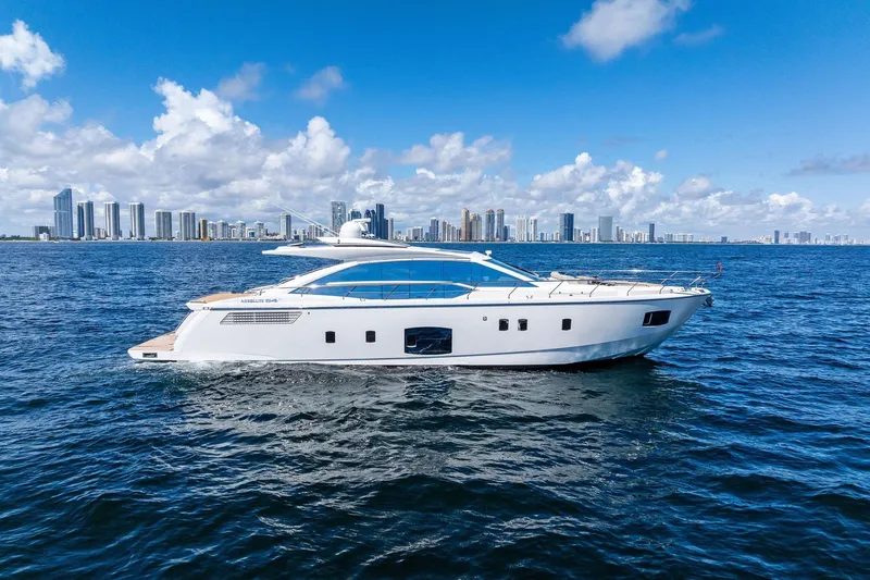 Blue Daksa Yacht Photos Pics Luxury Absolute 64 yacht cruising on ocean with city skyline in background, 2013 model.