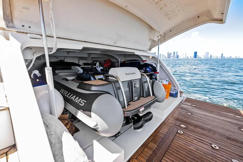 Blue Daksa Yacht Photos Pics Luxury yacht Absolute 64 with Williams tender in storage, ocean view, city skyline in background.