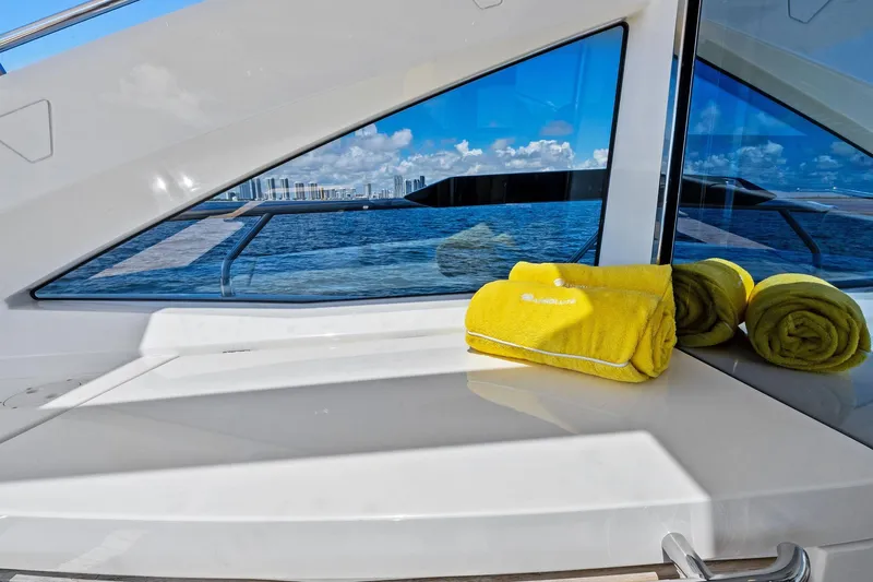 Blue Daksa Yacht Photos Pics Luxurious Absolute 64 yacht interior with yellow towels, ocean view, and city skyline, 2013 model.