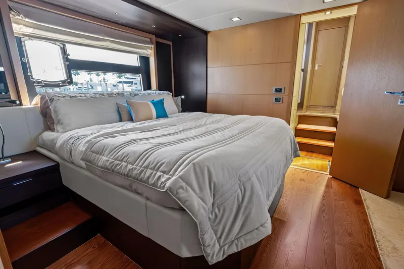 Blue Daksa Yacht Photos Pics Luxurious bedroom interior on a 2013 Absolute 64 yacht, featuring elegant wood finishes.