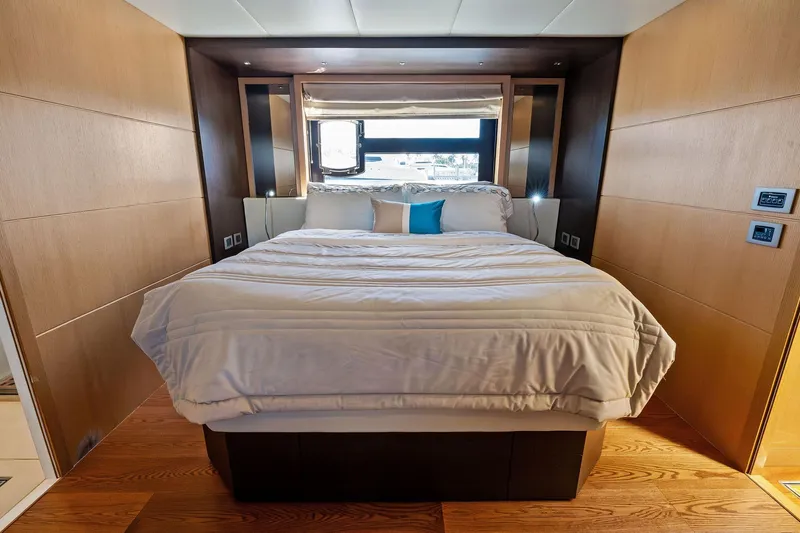 Blue Daksa Yacht Photos Pics Luxurious bedroom interior on a 2013 Absolute 64 yacht, featuring elegant wood paneling.