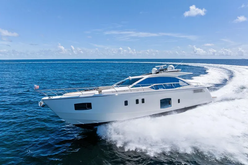 Blue Daksa Yacht Photos Pics Luxurious 2013 Absolute 64 yacht cruising on open ocean under clear blue sky.