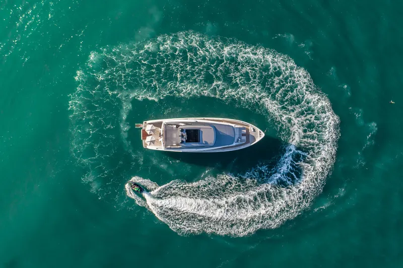 Violetta Yacht Photos Pics Aerial view of 2021 Sanlorenzo SX76 yacht with jet ski circling in turquoise water.