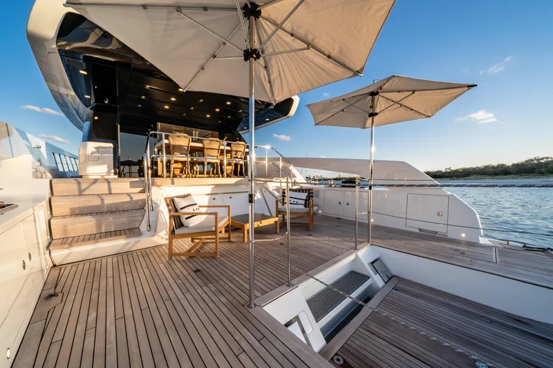 Violetta Yacht Photos Pics Luxurious 2021 Sanlorenzo SX76 yacht deck with seating, umbrellas, and ocean view.