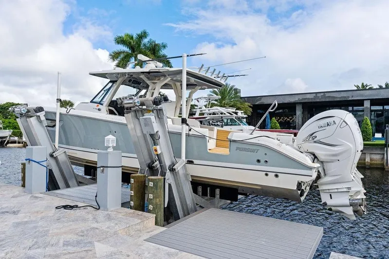 No Vacancy Yacht Photos Pics 2022 Pursuit S 428 Sport boat on lift by waterfront dock.