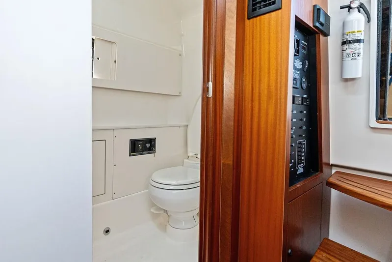 No Vacancy Yacht Photos Pics 2022 Pursuit S 428 Sport boat interior with toilet and control panel.