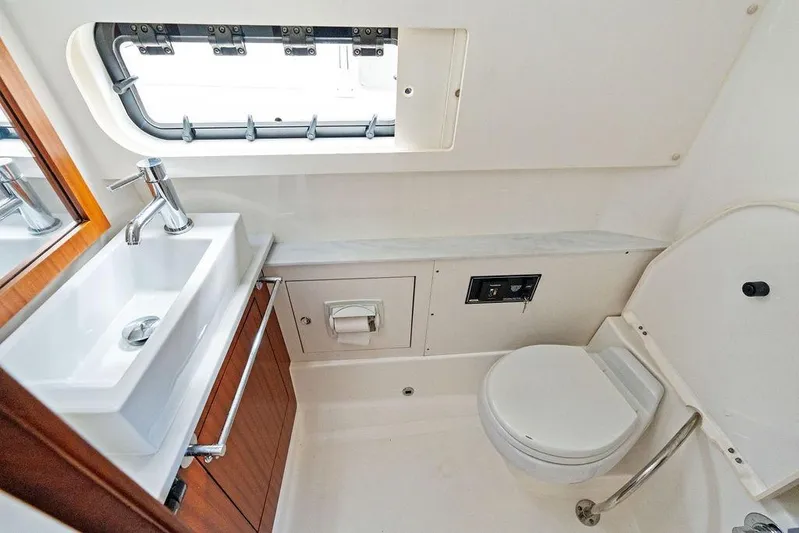 No Vacancy Yacht Photos Pics 2022 Pursuit S 428 Sport boat bathroom with sink, toilet, and window.